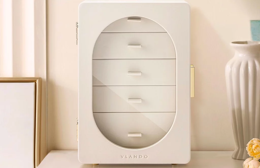 Beige and blush pink jewelry box with drawers, displayed in a bedroom