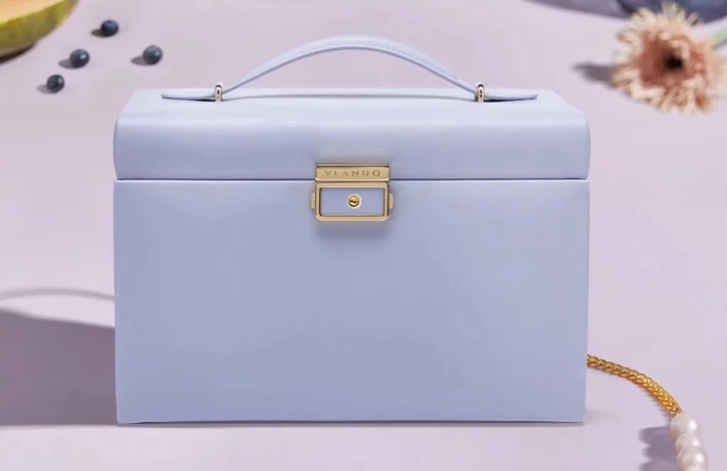 Close-up of stitching, hinge, and velvet drawer lining of jewelry box with lock