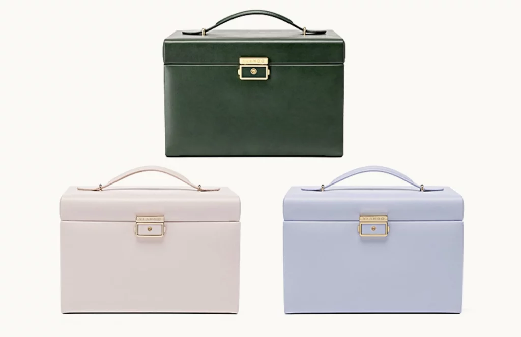 Blush, lavender, and emerald green jewelry boxes with lock on dresser